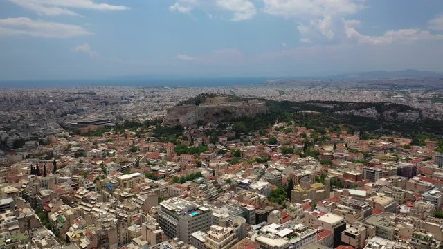 Aerial drone video of Athens and iconic Acropolis hill with Masterpiece Parthenon as seen from Lycabettus hill, Athens historic centre, Attica, Greece