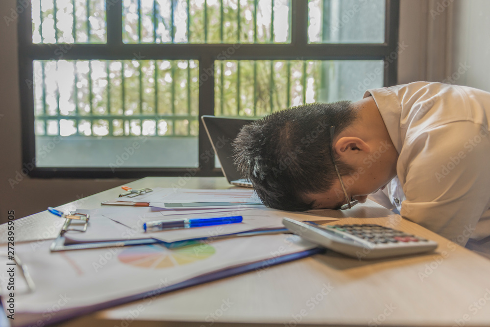 Wall mural Overworking man laying head on messy documents at workplace