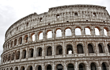 Fototapeta na wymiar Ancient architecture. The Coliseum is an oval amphitheatre in the centre of the city of Rome, Italy. It is the largest amphitheatre ever built. Landmarks of Italy.