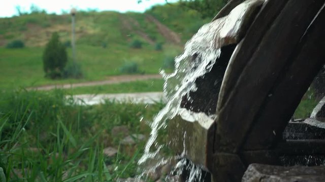closeup of turning wooden wheel of water mill outdoors. 4k footage