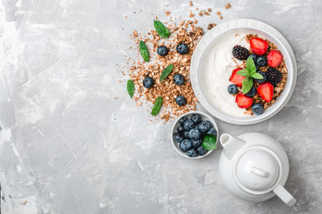 Fototapeta na wymiar Healthy breakfast with granola, yogurt, fruits, berries on white background.