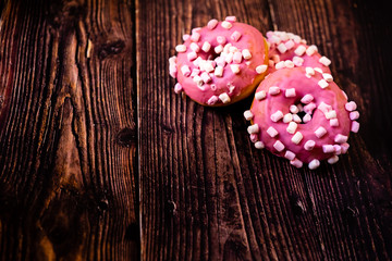 Pair of buns frosted with pink sugar and marshmallows, replete with saturated palm fat and polysaturated.