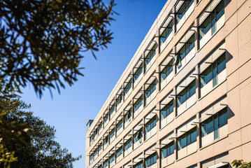 Facade of a modern building illuminated by the sun with gray background.
