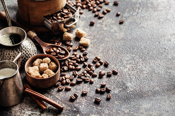 Coffee with coffee grinder and coffee beans on dark textured background.