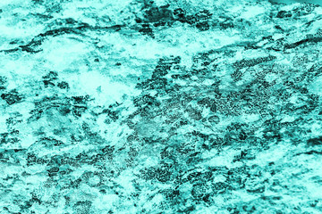 Vintage azure background. Rough painted wall of turquoise color. Imperfect plane of cyan colored. Uneven old decorative toned backdrop of aqzure tint. Texture of teal hue. Ornamental stony surface.