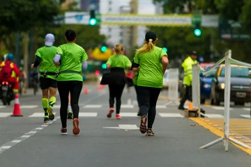 Fototapeten Group of men and women seen from behind run a marathon © simonmayer