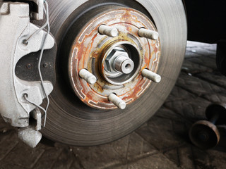 Disc brake on car in process of new tire replacement. The rim is removed showing the rotor and caliper.close up.