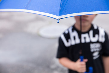 雨の日に傘を持っている小学生の男の子