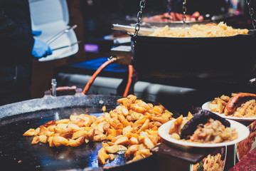 Variety assortment of different traditional european street food with sausages, mashed potatoes and stewed cabbage at one of the stalls at the Christmas market, Town Hall Square of Tallinn, Estonia
