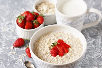 raw oatmeal with strawberries and milk. Oatmeal is filled with milk at night and in the morning get porridge.  healthy breakfast   