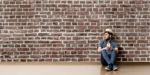 Young man sitting on floor, a moment for relax concept. Mixed media