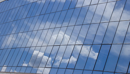 Obraz premium reflection of the sky with clouds in the glass windows of the building