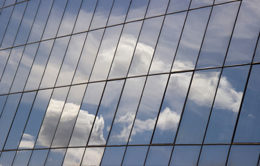 reflection of the sky with clouds in the glass windows of the building