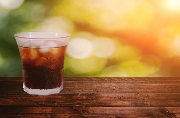A ice americano coffee on wood floor with green background