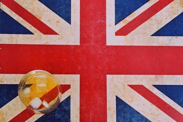 Fototapeta premium a cold glass of whiskey on Union Jack, england flag
