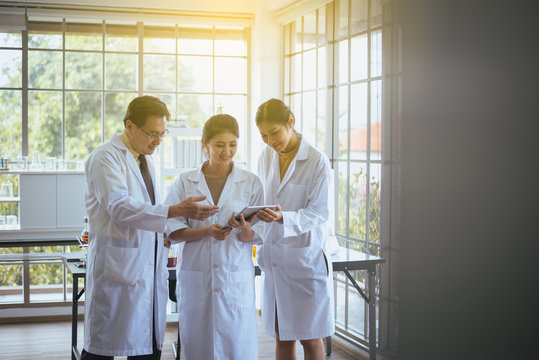 Scientist Senior Research And Assistant Using Tablet Computer Analyzing Data Information In The Laboratory