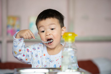 Little toddler boy having breakfast before school at home