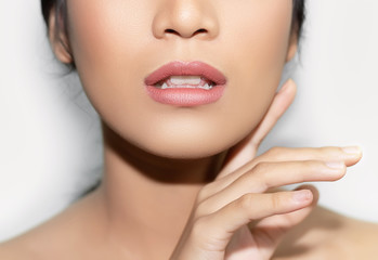 Fototapeta premium beautiful woman's face From nose to chest Showing bright pink lips And clean, healthy natural skin cleared, under the concept of beauty And skin care