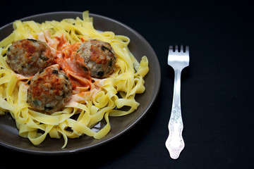 Pasta with meatballs on a dark background