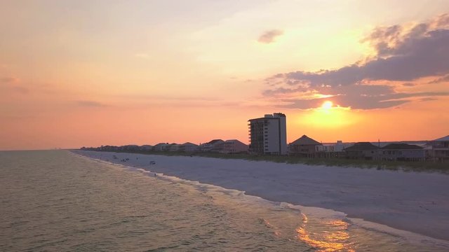 A dramatic aerial shot of the sunset on the beach with striking colors.