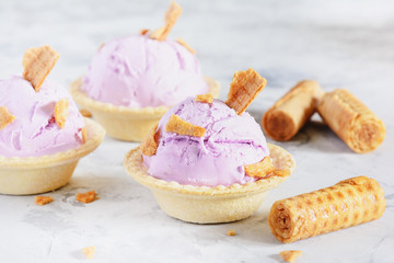 Violet Ice-Cream Balls in Biscuit Bowl with Waffle. Purple Ice Cream with Berry Taste in Basket. Sweet and Delicious Dessert. Iced Purple Sorbet and Bakery on White Background. Freezing Dairy Product