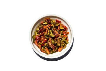 Saucer dish with granulated dried sweet pepper isolated on white background