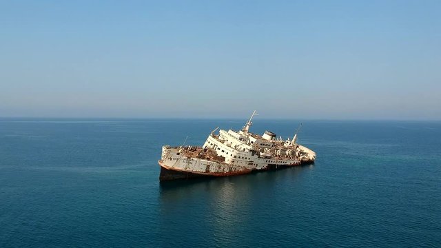 A white passenger ship wrecked on the coral reef at the Red Sea near the coast of Saudi Arabia