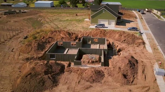 A drone shot spinning around a foundation and basement walls that had just been poured.