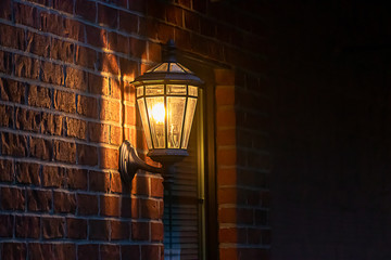 old fashoned glass wall mounted lantern on a brick wall