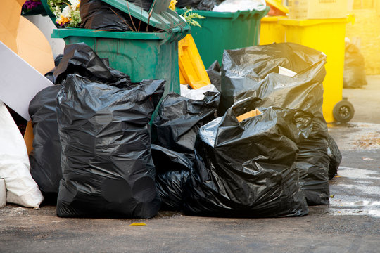 pile of  black garbage bags at city street, waste management in large cities
