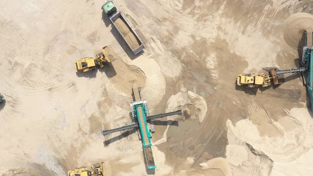 Aerial view loading bulldozer in open air quarry. Sand loading