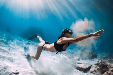 Fototapeta na wymiar Woman freediver with sand over sandy sea with fins. Freediving in Hawaii