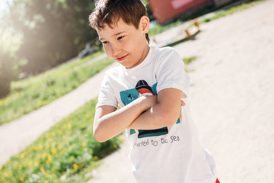 Charming Tween Boy With Freckles In T-shirt Standing At Summer Street