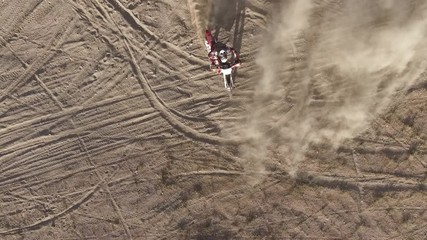 AERIAL: Overhead dynamic shot of a dirt biker as he does a few quick skidding turns on his Honda CRF motorcycle in the desert. - Powered by Adobe