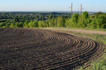 agriculture plowed field and blue sky with clouds in sunset