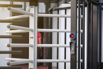 Closed entrance turnstile with pass and ticket checking module, access denied red sign. Access equipment on entrance gate with red cross. Automatic buffle gate at entrance. Barriers, security concept