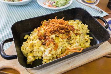 GRASBRUNN, BAVARIA / GERMANY - June 9, 2019: Close up of traditional swabian Käsespätzle (cheese noodles) - a popular dish in Southern Germany. The main ingredients are eggs, milk, flour and cheese. 