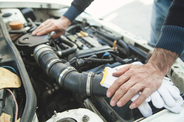 Mechanic repairs the car engine.