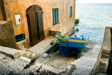  Fishing boat on the pavement in front of old building in Seaside town Scilla , traditional typical...