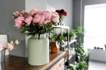 The counter of the flower shop. Pink peonies in a metal vase. Beautiful peony flower for catalog or online store. Floral shop concept . Beautiful fresh cut bouquet. Flowers delivery