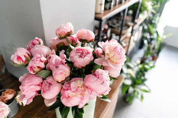 The counter of the flower shop. Pink peonies in a metal vase. Beautiful peony flower for catalog or online store. Floral shop concept . Beautiful fresh cut bouquet. Flowers delivery