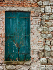 Fototapeta na wymiar Antique door with wooden plank panels of a rural house, with iron fixing parts, Italy.