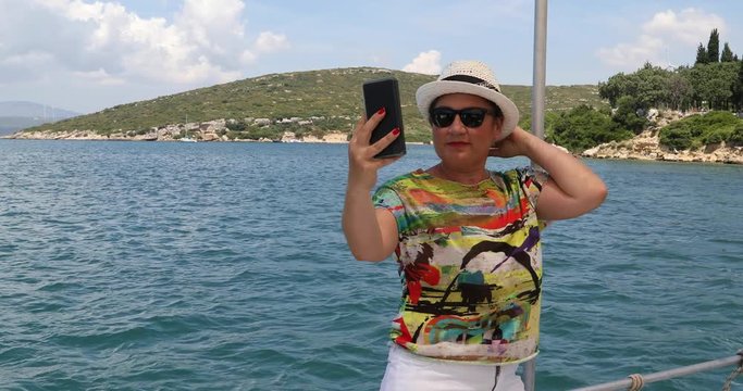 Portrait of a female tourist people in yacht deck making selfie on smartphone at summer vacation