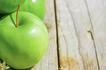 Freshly cropped geen apples on wooden table, close up