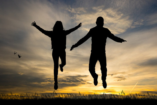 man and girl jumping at sunset