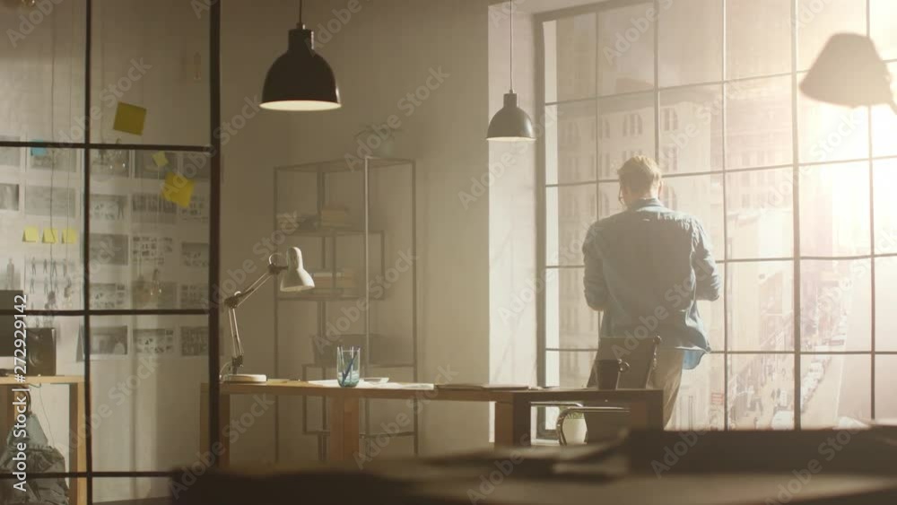 Aufkleber professional music video editor holds laptop while looking out of the window onto big busy city seek