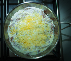 meat under the cheese lies in a skillet, food