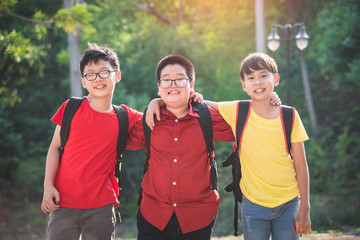 Three asian schoolboy standing and smiling together in school park