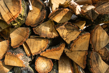 The wall is laid out with the ax by the ax wood in the village, the texture of wooden firewood.