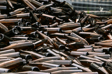 whole and broken brown bottles are scattered on gravel.Concept: waste recycling, disposal of garbage